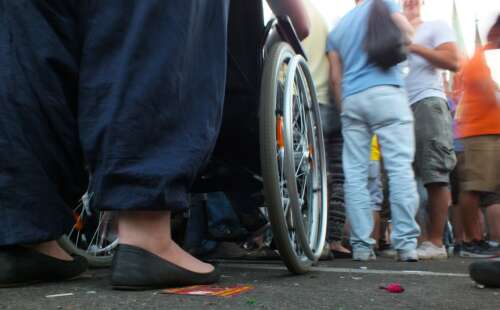 Nahaufnahme eines Rollstuhls in einer Menschenmenge